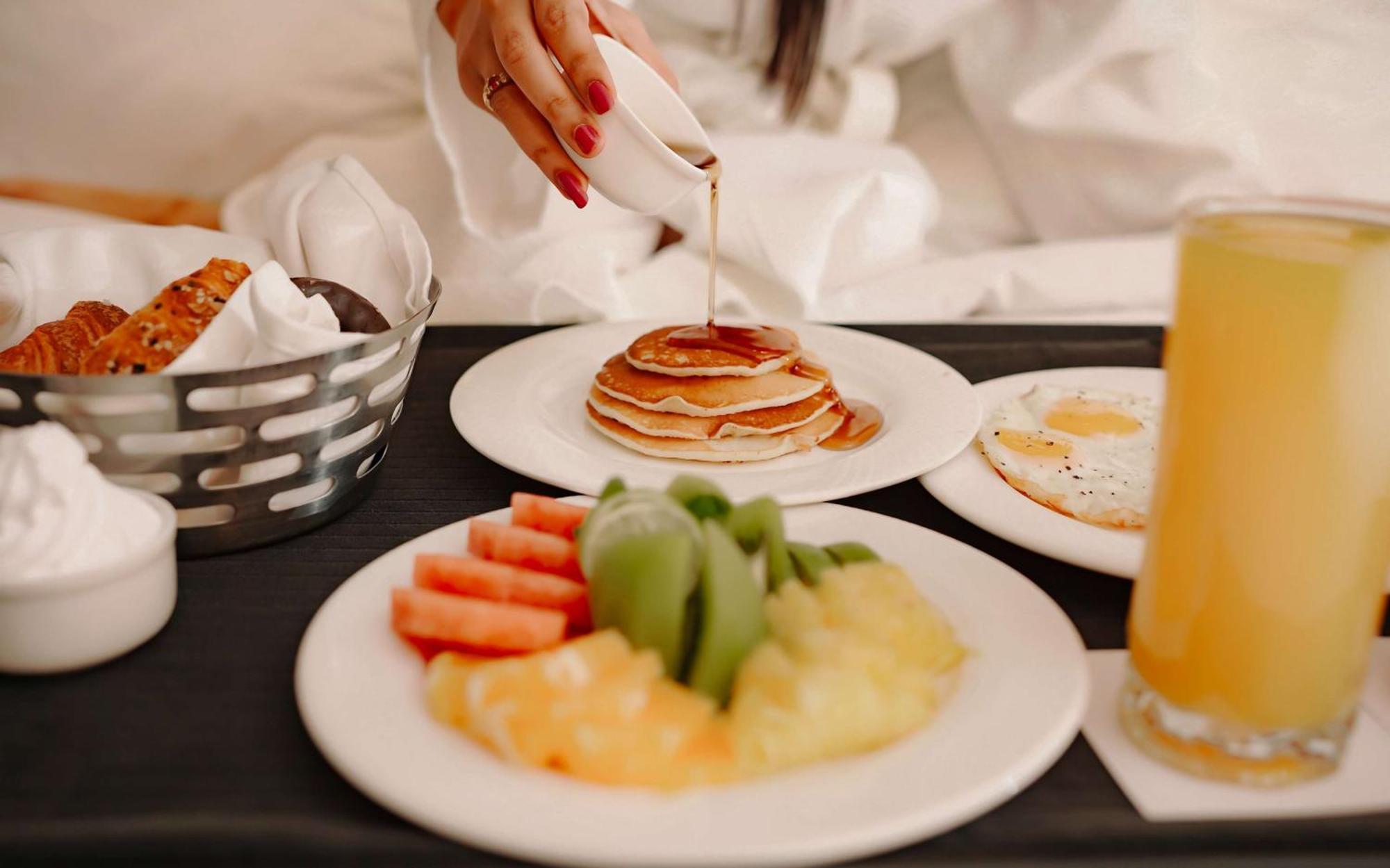 阿姆利则丽笙酒店 外观 照片 A woman pouring maple syrup on a stack of pancakes